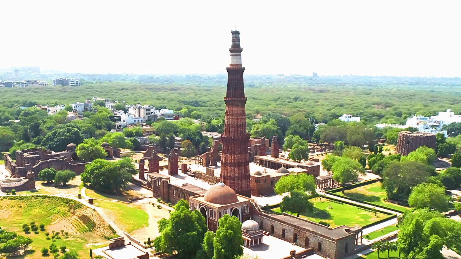 Qutub Minar, the 72-metre tower framed by ruins and trees at the heritage complex
